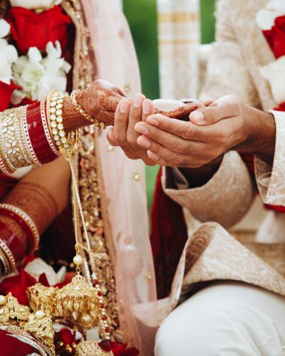 Hands of indian bride and groom intertwined together making authentic wedding ritual